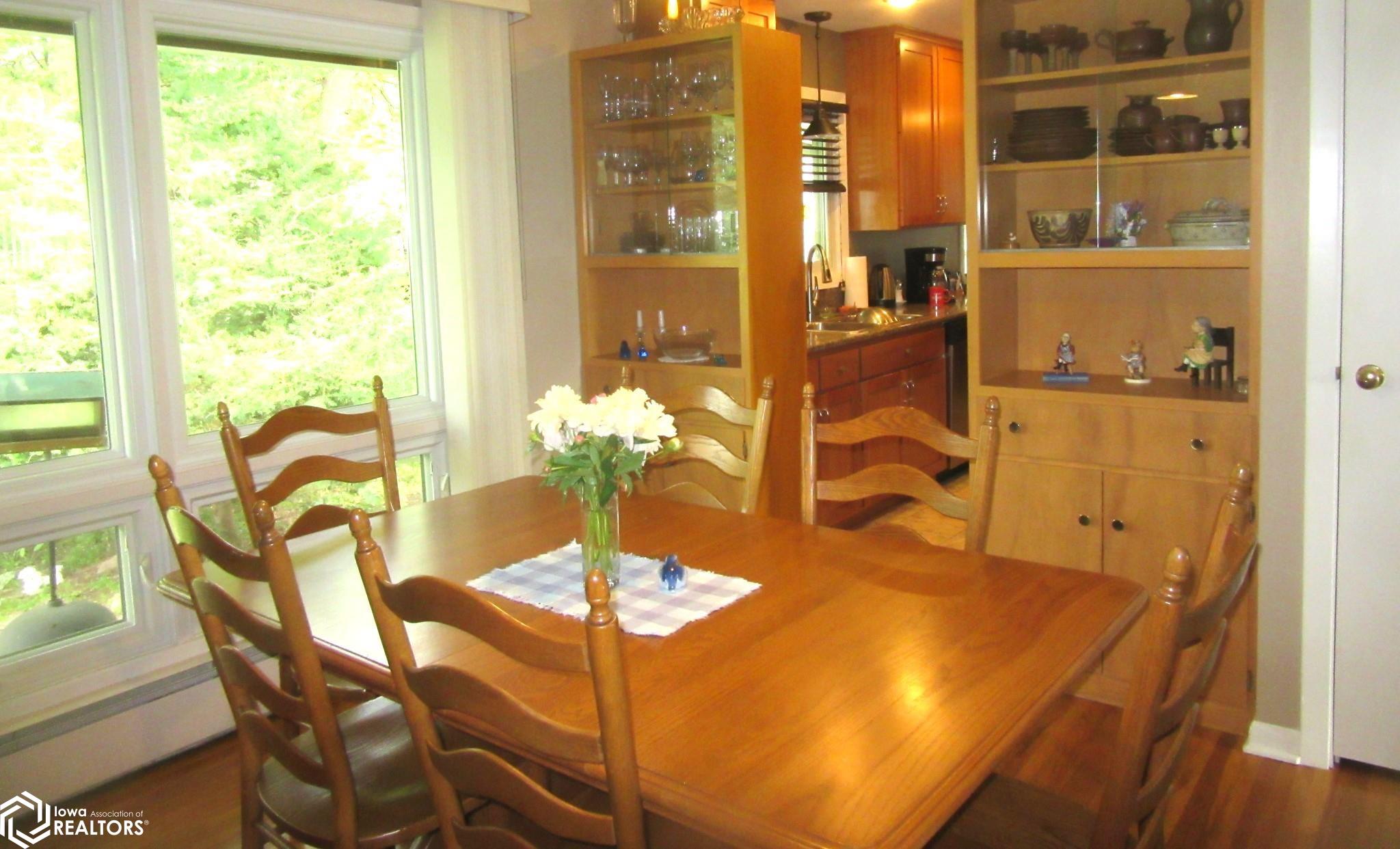Dining Room with Glass front storage and windows overlooking the back yard.  Nice garden, bird watching, and more!