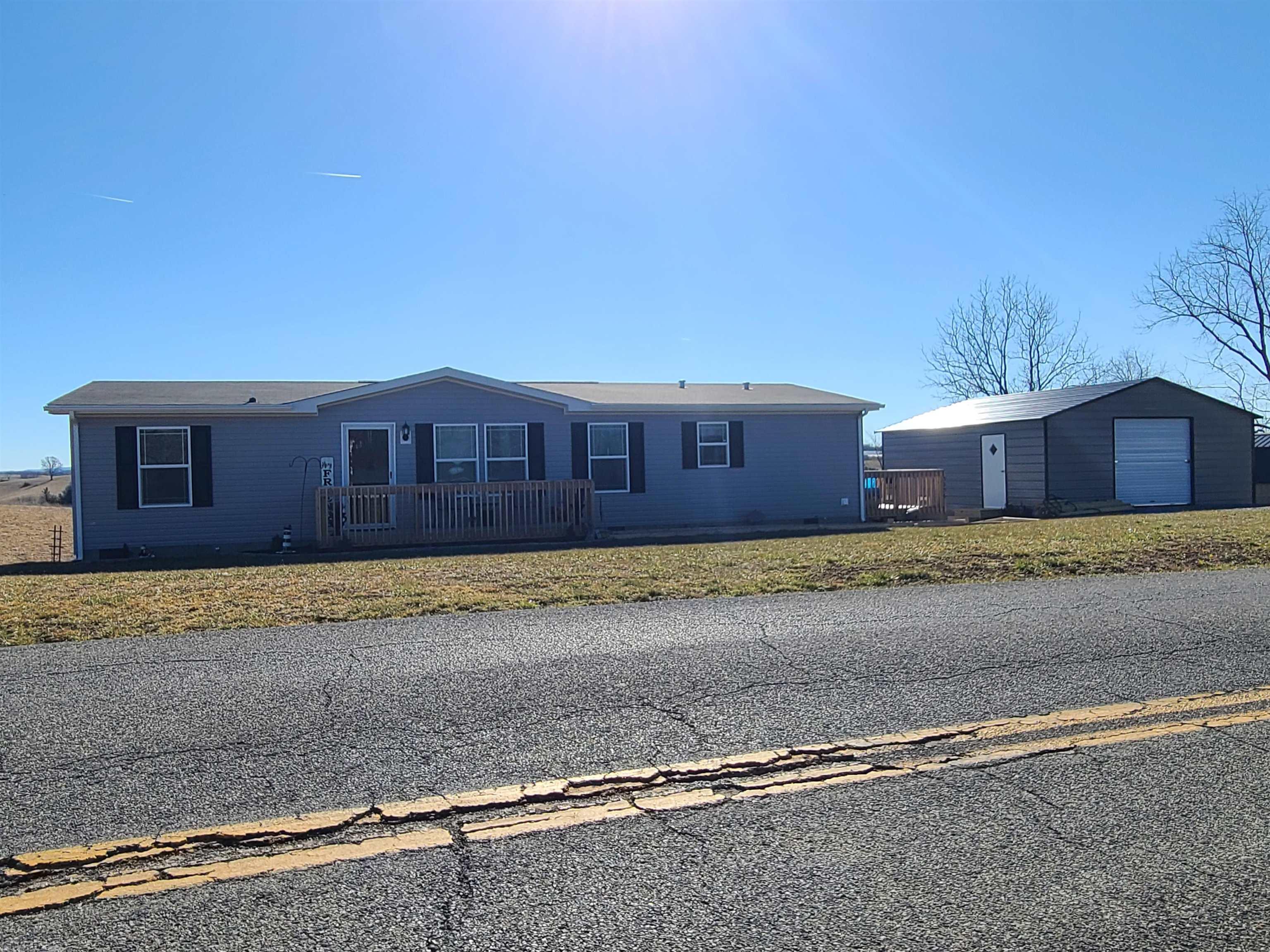 MOTIVATED SELLER with price improvement! If you're looking for move-in ready, look no further. This LIKE-NEW home, less than 1 year old, is for you! A beautiful country setting awaits you on just over 1 acre of rolling rural meadow. Relax on a newly built front deck and an additional side deck. Step off your deck and walk right into a spacious 24x24 newly built garage/workshop! Two vehicles could fit with plenty of room for storage, tools, a refrigerator, freezer, or anything else you might want. Step into the front door and admire the beautiful stone hearth and gas log fireplace! Just above the fireplace is a large screen television that  stays with the home! An open floorplan leads you into the dining room and kitchen. Like new appliances come with the home, including refrigerator (brand new), range, dishwasher and a like new washer and dryer! The master bedroom has its own bathroom and a walk-in closet.  This is a like-new home ready for your touches! FHA/Govt loan friendly!