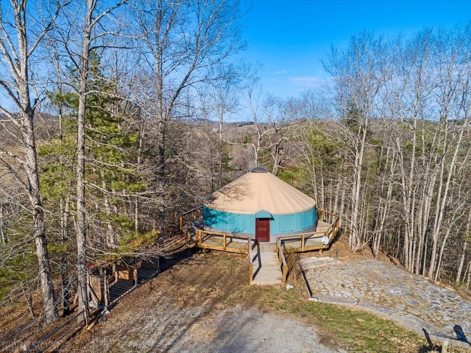 Serenity at it's finest.  Beautiful mountain setting with 319' frontage on Little River.  The location offers complete privacy.  The property offers a 30 ft diameter yurt with a full wrap around deck.  The interior of the yurt has a wood stove for heat, electric range, refrigerator, full bath, loft and custom hardwood floors that have just been refinished.  The property also has a 30 x 40 locust pole barn that has a great covered front porch for relaxing, water, electrical and is mostly insulated.  The barn is set up for what could be expanded living space, loft area for storage and great areas for tractors or livestock.  Enjoy the 4 seasons on the deck of the yurt or at the stone patio area.  Well and septic (3 bedroom) already installed.  Use the yurt to live in while you build your dream mountain home or keep this diamond for your own personal get-a-way place.