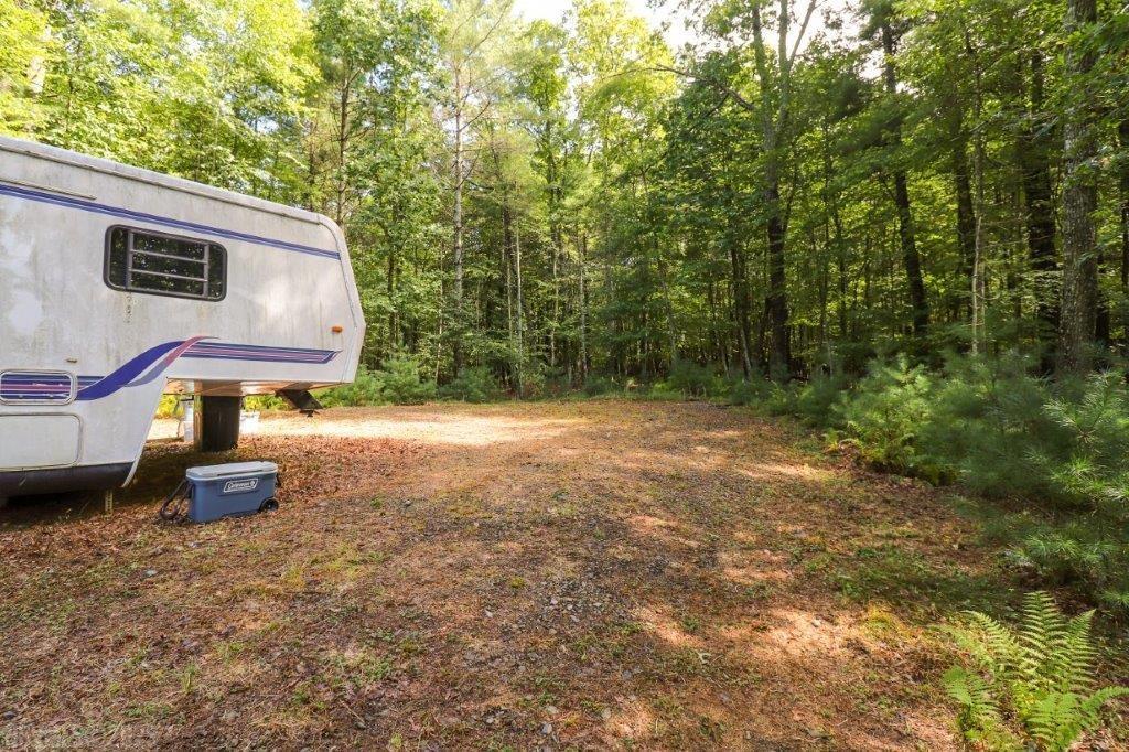 Private building lot in a rural subdivision. This lot is nearly 2 acres and features a cleared building site, driveway, well, septic and temporary electric already in place. Also features an older 30+ ft camper. Great place for a weekend retreat! Use as a camping weekend escape or build your forever home here! Has creek frontage across the road with steep access but nice along the creek bottom.