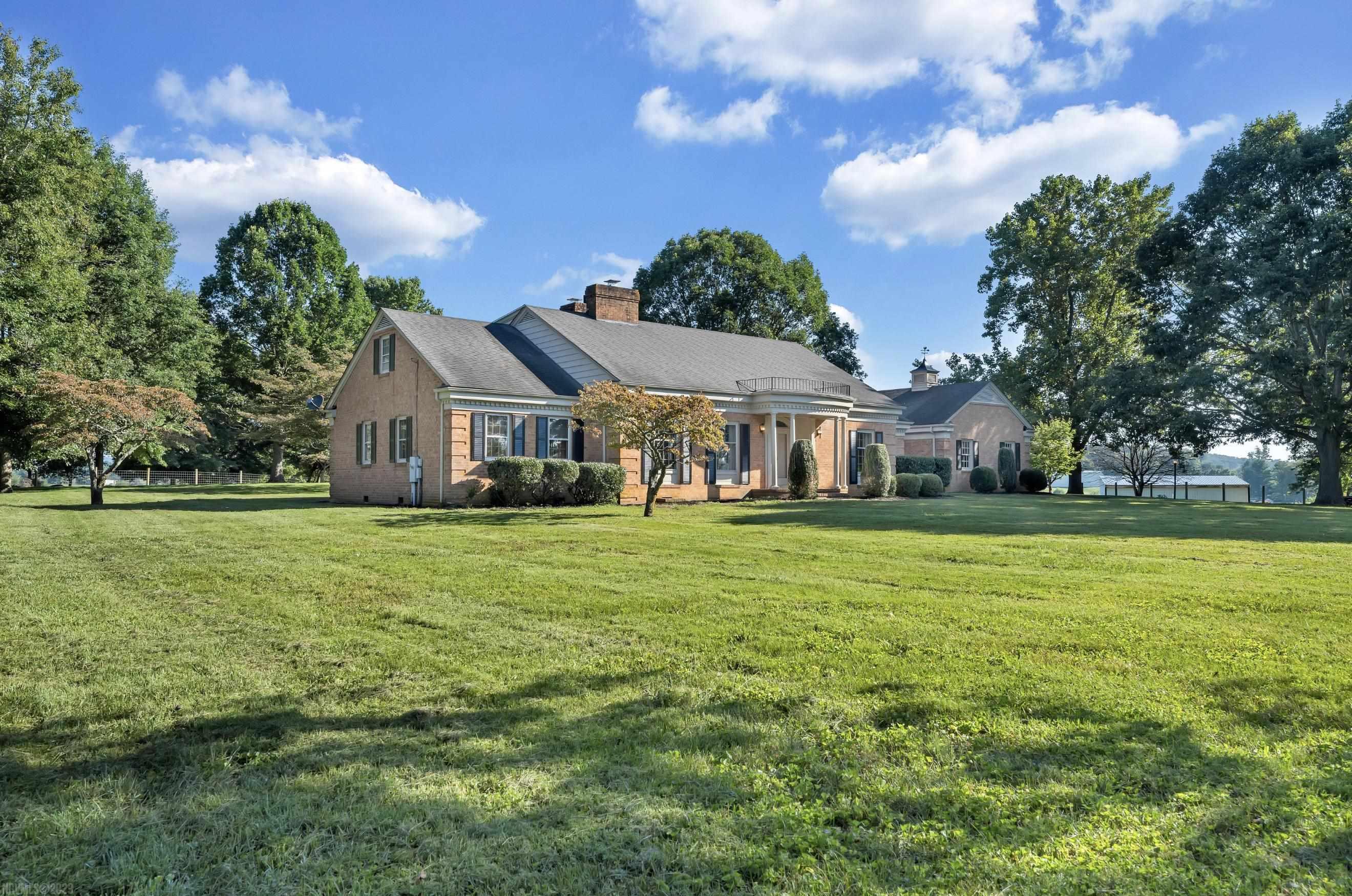 This captivating colonial-style gem on 55+ acres of picturesque rolling pastureland is your opportunity to experience the perfect blend of country living and modern comfort. A blacktop driveway, embraced by majestic mature trees, leads to the double detached garage and custom-built brick home. There is also an additional backyard garage and barn in the pasture. Inside, discover a meticulously maintained interior that seamlessly blends charm with modern updates. The open floor plan flows into a spacious kitchen, a cozy breakfast area, and a sunken family room with a wood-burning fireplace and built-in bookcases. The living and dining rooms provide ample space for entertaining and making cherished memories. The primary bedroom, conveniently located on the main floor, features an ensuite bathroom for added privacy. Upstairs, three large bedrooms, a full bath, and a spacious bonus room await your personal touch. Finally, multiple walk-in attic spaces ensure all your storage needs are met.