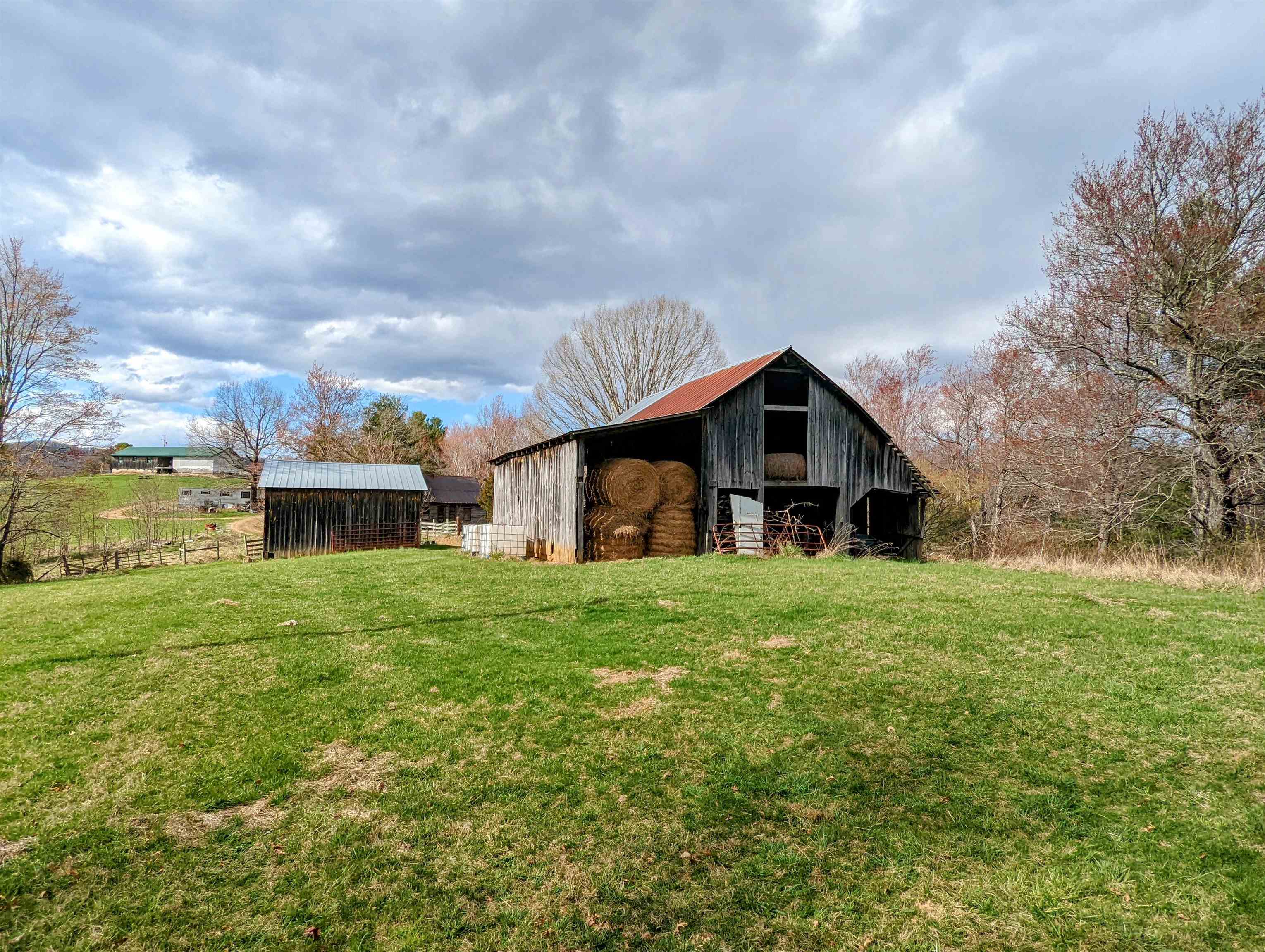 Nestled in Indian Valley, VA, this 25 +/- acre property offers a prime location near Floyd, Hillsville, Radford, and Christiansburg, VA. With a history as a working farm for cattle, this versatile land can be restored for farming, transformed into a hunting and recreation haven, or used as a potential house building site. Enjoy sweeping southern views and the tranquility of a spring-fed pond on the premises. The property features barns, sheds, and a spacious open field perfect for grazing or hay production. While fences may require some maintenance, the mix of open fields and wooded areas provides a diverse landscape. Accessed via a shared driveway on a private road, this property is currently part of a larger 35+ acre parcel. It will be subdivided to a minimum of 25 acres, with the seller retaining the remainder where their residence is situated. Interested buyers also have the option to acquire the entire property, with the seller retaining a life estate at the residence.