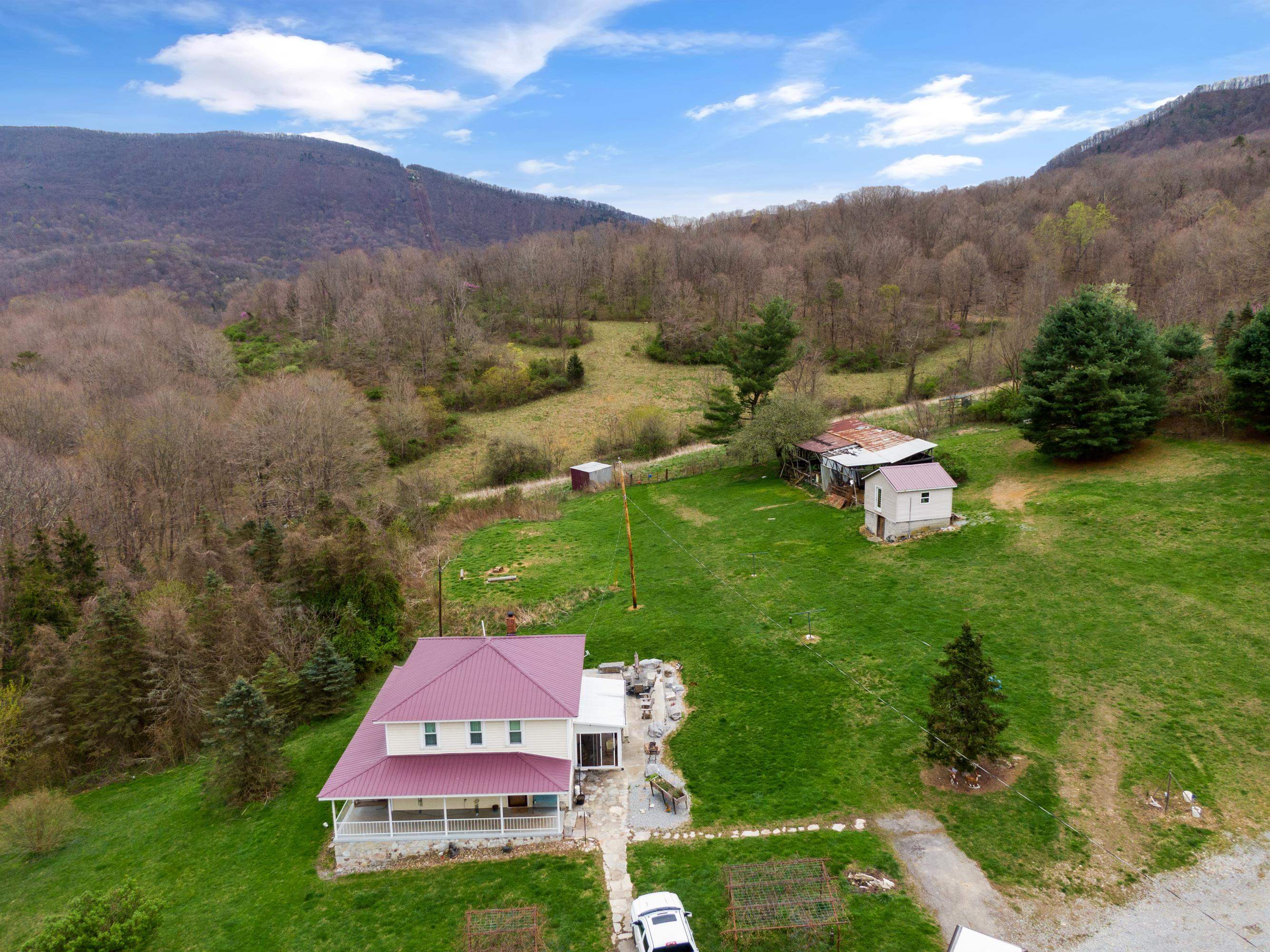 Nestled within the picturesque town of Narrows lies a sprawling estate offering a rare blend of natural beauty, agricultural potential, and recreational opportunities. This 400+ acre farm presents an unparalleled opportunity to embrace the timeless allure of countryside living. Boasting rolling hills, this property features fertile land suitable for crop cultivation or livestock grazing. At the heart of the property stands a farmhouse, exuding timeless elegance and rustic charm. With traditional architectural elements and modern amenities, the residence offers spacious living areas, cozy bedrooms, and panoramic views of the surrounding countryside. This expansive farm enjoys a privileged location, providing both seclusion and accessibility. Other standout features include a 5,000 square-foot industrial garage with electricity, a finished 16x16 insulated workspace for all of your creative needs, four natural springs, and miles of stunning trails to explore on the property.