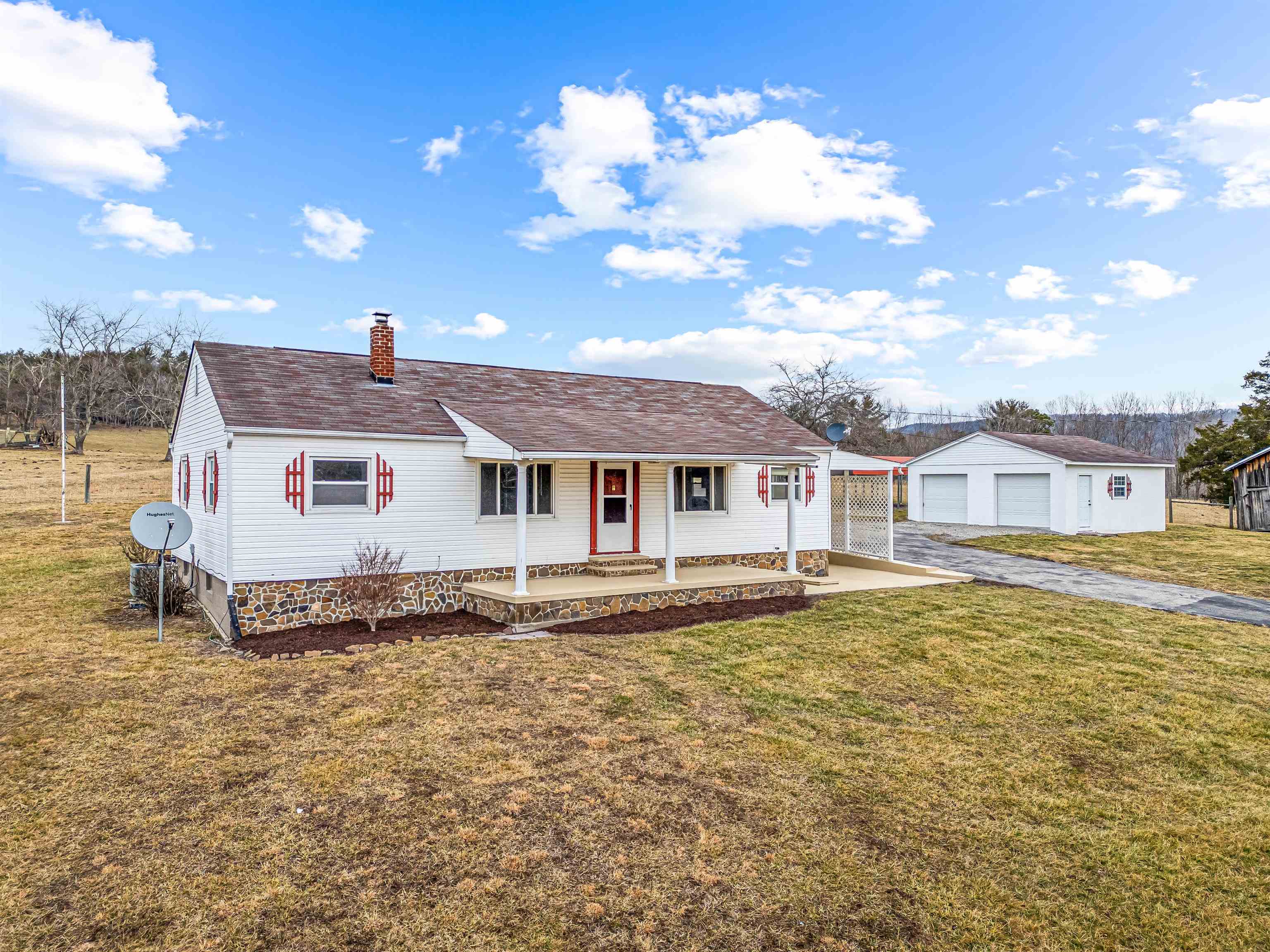 This charming 3 BR 1 BA home sits on a very nice +/-0.86-acre lot, and includes a full, unfinished walk-out basement, providing ample potential for customization and additional living space. Additional features include a carport, outbuilding for additional storage, and a large 2 car detached garage. Beautiful country view right off the front porch! Main source of heat is the heat pump but the home also has a propane gas free-standing fireplace in the living area, a wall-mounted propane heater in the mud room, and a wood burner in the basement ensuring warmth and comfort. Wood flooring enhances the appeal of much of the home. The property is fenced and has a paved driveway with paved road frontage. Enjoy having your own apple, pear, and plum trees as well as the grape vine in the backyard. The home is served by private well and septic system. This well-priced home is a great deal for anyone looking for peaceful country living!