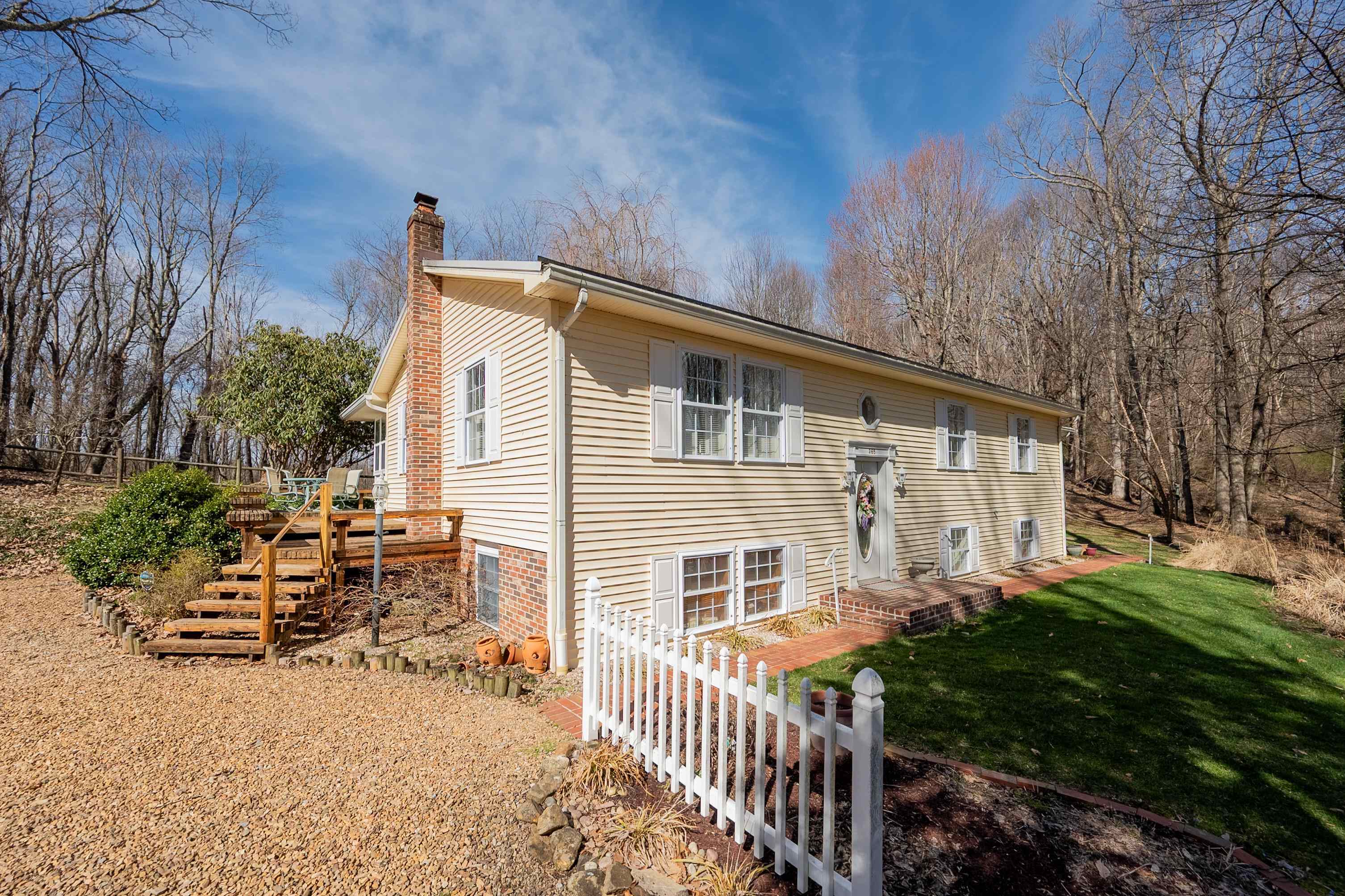 This charming split-foyer cottage, nestled in the foothills of Southwest VA, offers the perfect combination of comfort and privacy. The home features 3 BR's and 3 BA's with +/-2870 total finished sq. ft.. Additionally, there is a +/-230 sq. st. unfinished portion of the basement. The exterior includes durable vinyl siding and brick, a metal roof, and leaf filter gutter guards. A heat pump provides efficient heating and cooling, and the large open deck and fire pit area offers ideal spaces for outdoor relaxation. There’s also a storage building and a 2-car detached garage with a loft above. Inside you'll find wood and tile flooring, as well as carpeting in certain areas, a water softener, and security systems. Two fireplaces in the basement—electric and propane. A lovely enclosed porch provides an ideal spot to enjoy your morning coffee. The primary BR is amazing and has a jet tub, vanity, and gigantic walk in closet! Lots of privacy, well maintained, and ready for any type of loan!