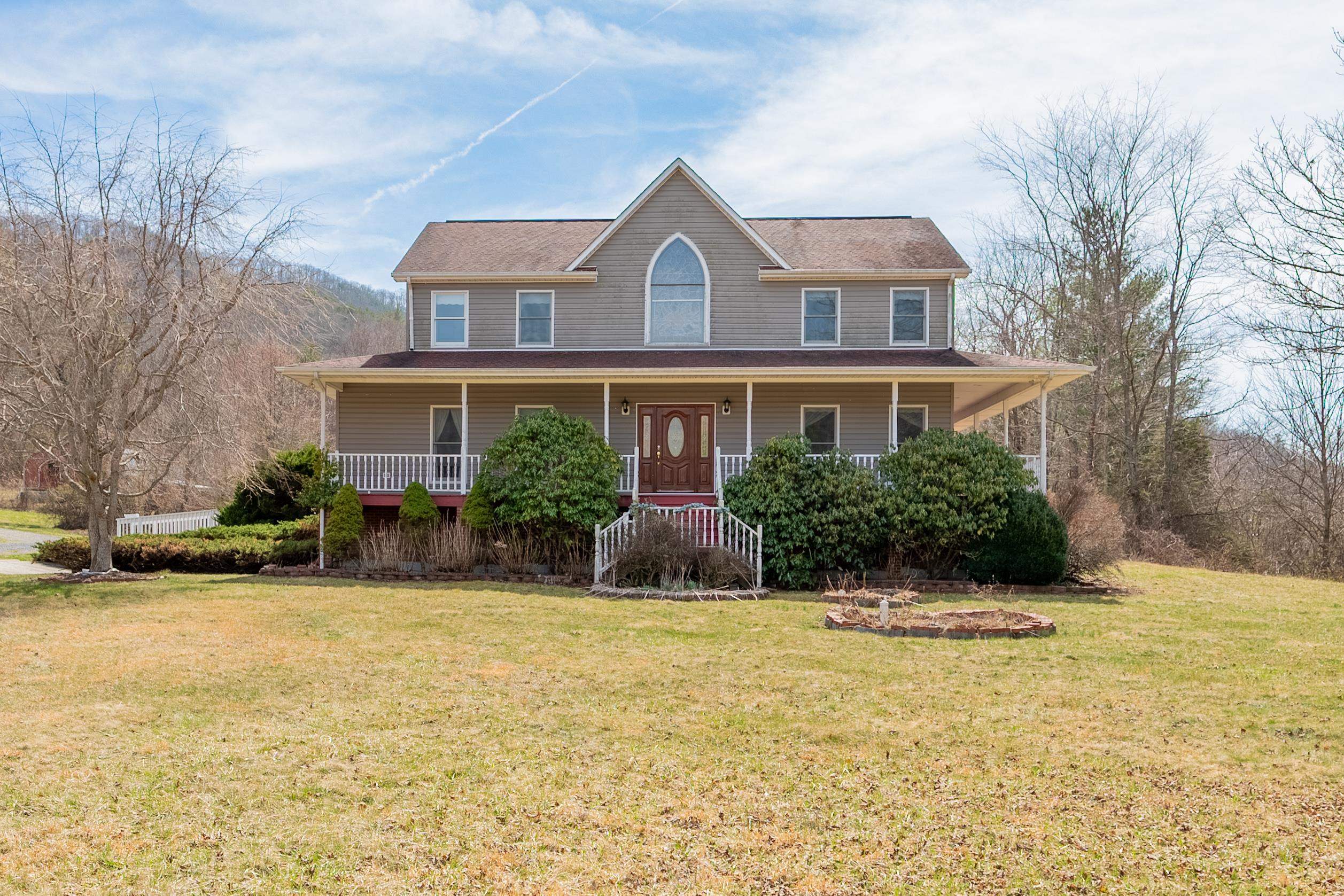 This is a must see home.  It has everything from a 24 foot vaulted ceiling to your own private library.  The home has some beautifully designed stain glass windows which allow radiant sunlight into the home.  You can sit on your wrap around porch and just enjoy the views of the valley.  For anyone who enjoys the outdoors this property joins the National Forest.  There is a metal building which can be used for a workshop. There is also a pole barn which could be used for horses and cattle.  You will have to see this home to appreciate all that it offers.