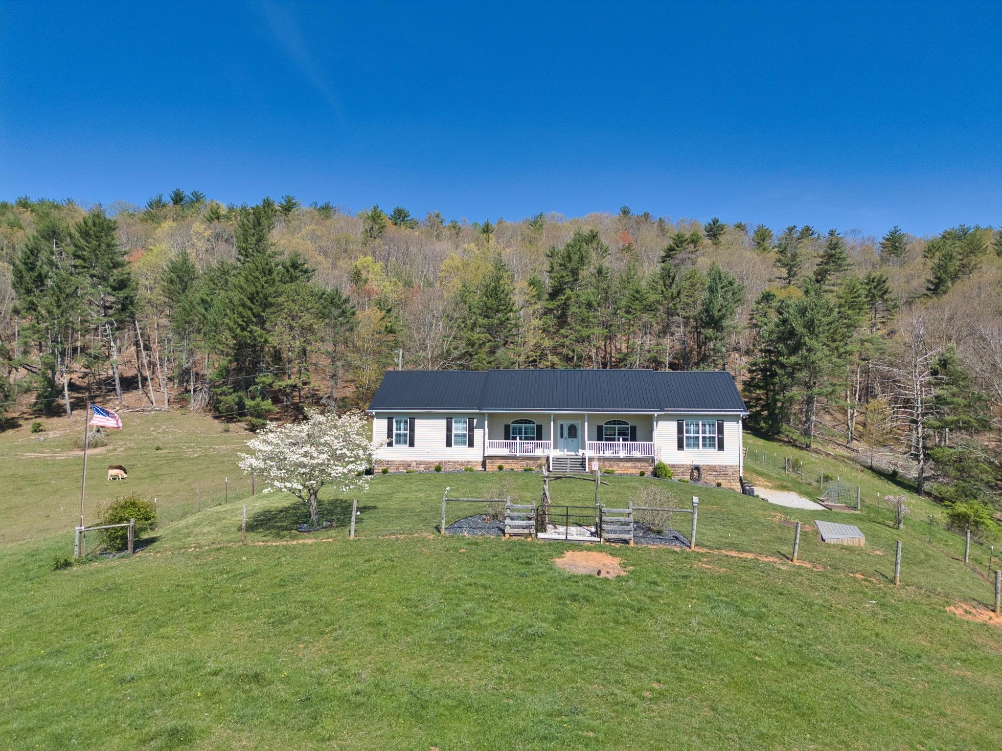 This Gorgeous Farm sits on 21+ open acres adjoining the Jefferson National Forest in the back yard with beautiful views, fenced yard fenced pastures, hay fields, barns, cattle working pens and located minutes to I-77. This three bedroom, two bath home has a covered front and rear porch, arched doorways and a built-in desk with an abundance of cabinets tucked away just off the kitchen. Enjoy the picture window in the primary bedroom and the updated luxury bathroom has a beautiful tiled, walk-in shower, linen closet, grab bars and walk-in closet. Finished, full, walk-out basement for additional living space or use for storage. The woodstove is connected to the duct work for fabulous warm heat in the winter. This treasured home is move-in ready and ready for your horses or cattle today!  Call for more information and a private showing!