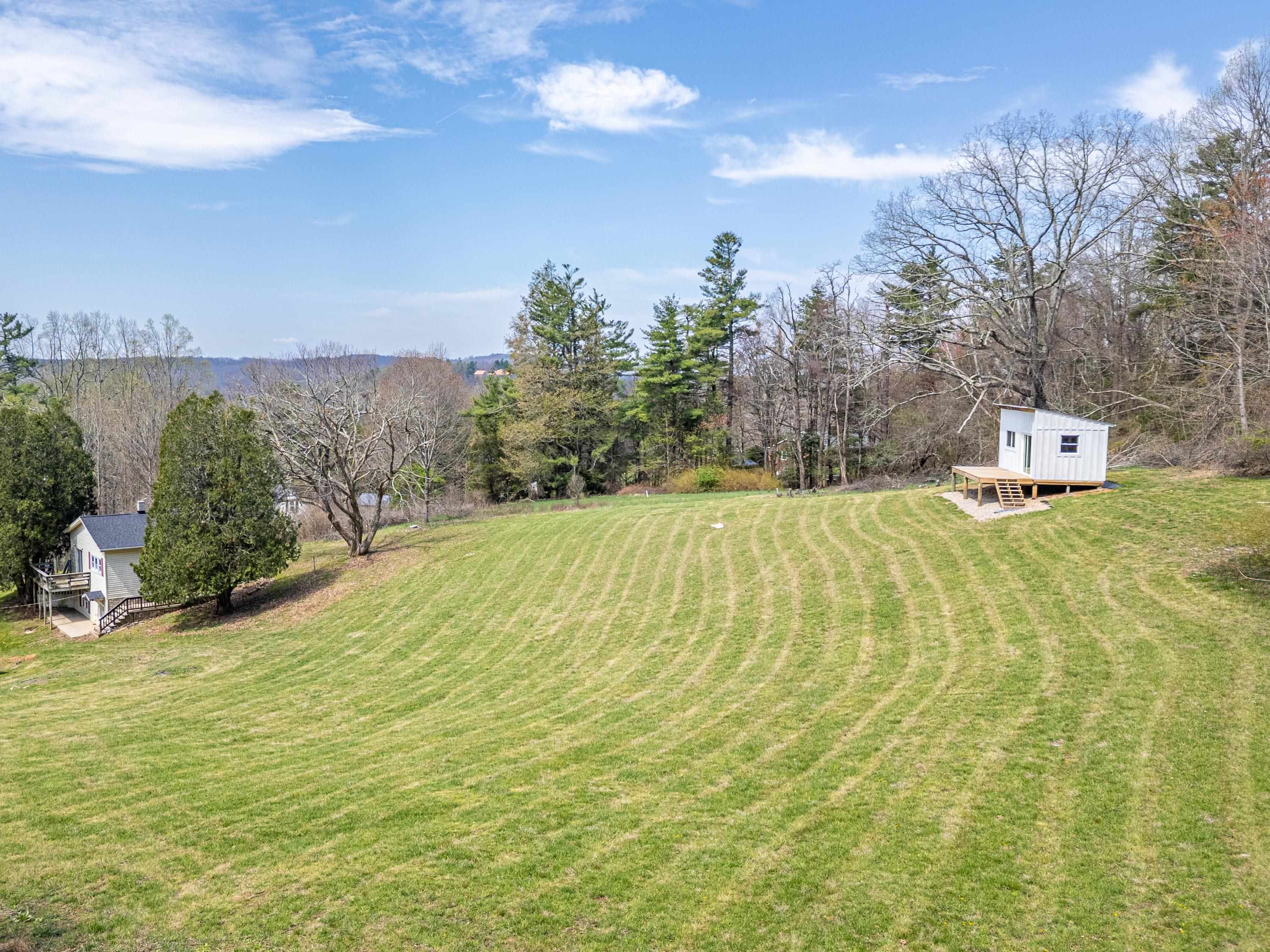 Prime Blue Ridge Parkway opportunity featuring 2.25+ acres with direct Parkway access and valuable infrastructure already in place. This rare property includes a main home shell, garage, and bonus tiny home shell with deck, plus established well, septic, and electric service—significantly reducing development costs and timeline. Enjoy premium mountain views on flat to gently sloping terrain with multiple build-ready areas. Ideally located within walking distance to Fancy Gap Country Store and Deli, just 10 minutes to Hillsville, minutes from I-77, and a short drive to Mount Airy, NC. Perfect for Airbnb investment, tiny home community, or your forever mountain retreat. Skip typical development costs with this ready-to-finish property where mountain living dreams become reality. Sold AS-IS.