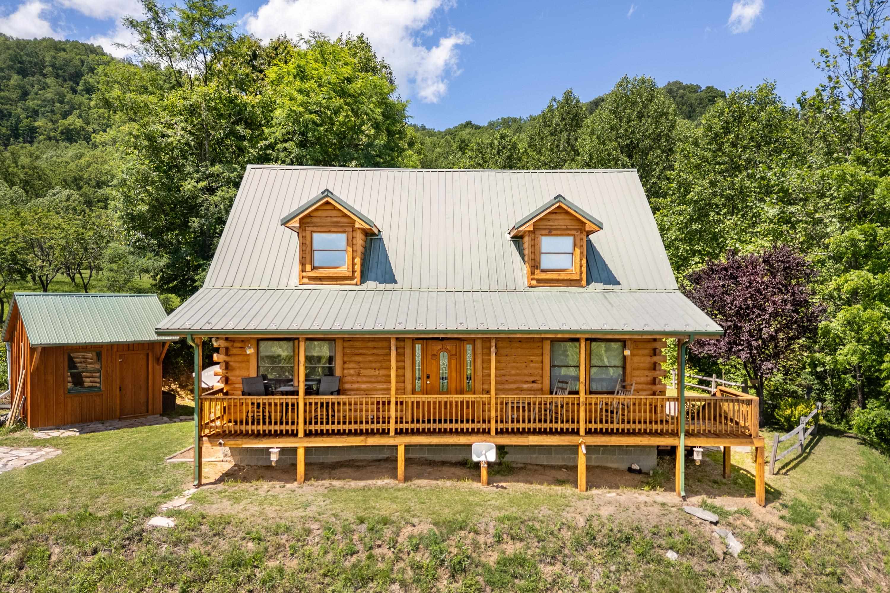 Experience unmatched privacy and sweeping 60-mile views of the Piedmont from this stunning 3-bed, 2.5-bath log cabin on 4.8 unrestricted acres—just 2 miles from the Blue Ridge Parkway. This rare, non-HOA property offers total seclusion without sacrificing convenience: only 30 minutes to Mt. Airy, and just over an hour to Winston-Salem, Blacksburg, Greensboro, and more.  Fully upgraded in 2023 with a new HVAC system (warranty included), tankless propane water heater, and whole-house Generac generator, this home blends rustic charm with modern peace of mind. The exterior was professionally stripped and re-stained in late 2024, ensuring long-term beauty and durability.  Currently a VRBO rental, the property offers exceptional income potential or can serve as your private mountain haven. With its unrivaled views, ideal location, and luxury upgrades, this is truly a once-in-a-lifetime opportunity to own a premier Blue Ridge escape.  Home comes mostly furnished, with some exclusions.