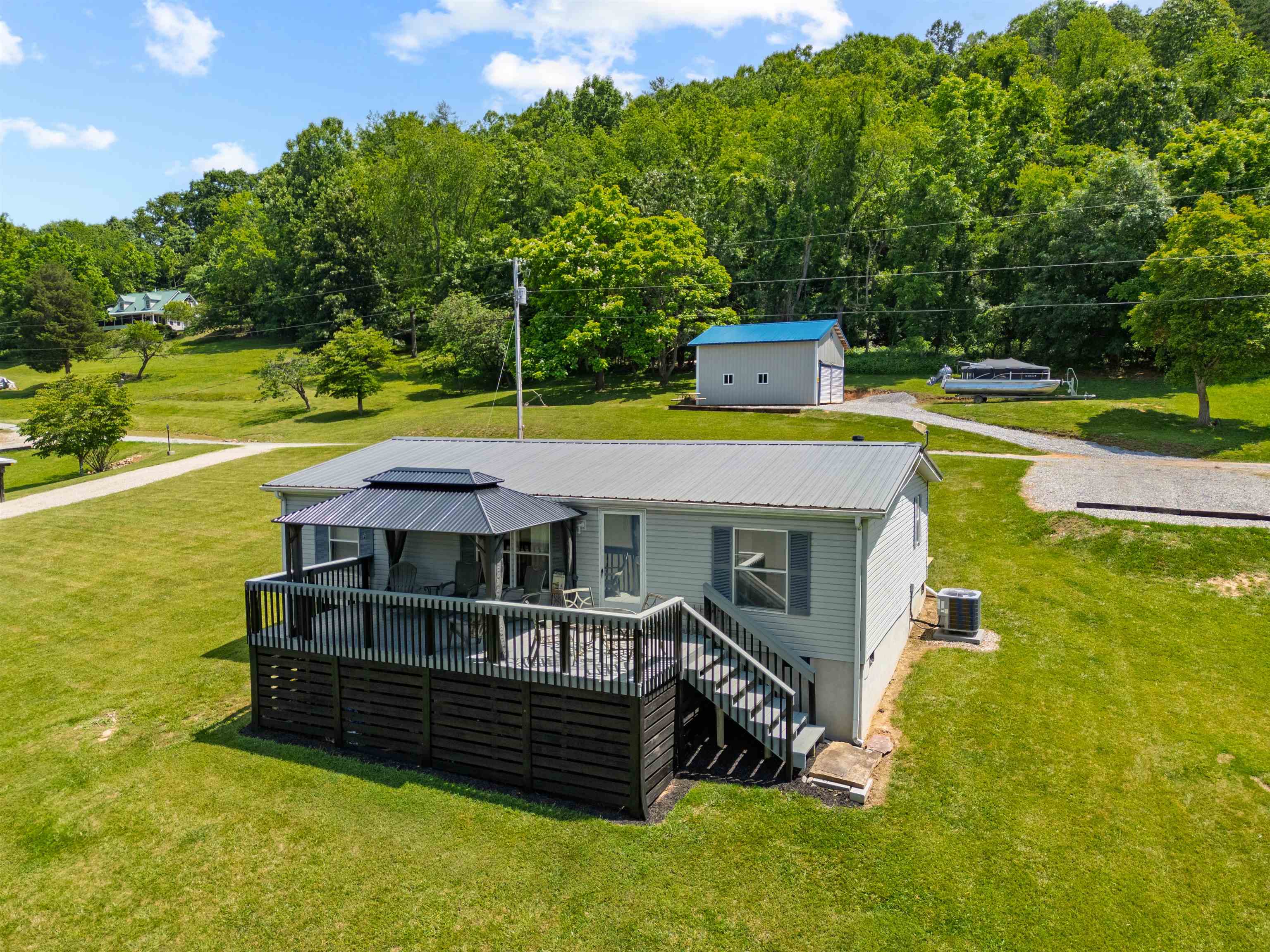 Experience waterfront living with this beautiful property located at the headwaters of Claytor Lake! Offering over 100 ft of waterfrontage & stunning views year-round, this move-in-ready home is perfect for those seeking a serene lake or river lifestyle. The property comes furnished & offers many low maintenance features including LVP, metal roof, & recent replacements of the heat pump & well pump. This~3/4 of an acre features: Both a gazebo-shaded deck at the house and a tree-shaded lower shore-side deck for soaking in the views. Newer metal outbuilding/garage with ample space for 2+ cars or lake toys & equipment. A private dock for easy lake access. The community Common Area features a boat launch & parking. Less than 1.5 miles from New River Trail State Park, ideal for hiking & biking. This home is ideal for a year-round residence or a 2nd home, offering everything needed to start lakefront living!
