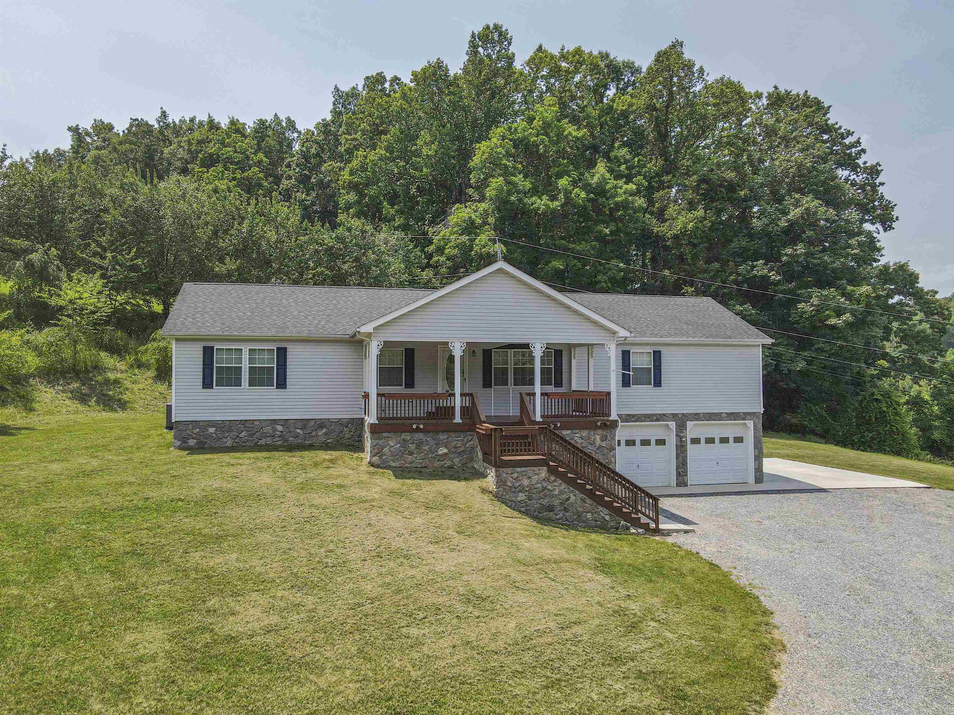 Set on over 35 private acres with creek access, wooded trails, cabin, and serene views, this home offers main level living and room to roam. The open living room features a cozy gas fireplace, with a split-bedroom layout—the primary suite includes a jacuzzi tub, while three additional bedrooms share a full bath. Enjoy the covered front porch, back deck, and fenced yard perfect for pets or play. The lower level includes a second kitchen, home gym space, tons of storage, a 4-wheeler bay, and access to the two-car garage. A peaceful, versatile retreat with endless possibilities.