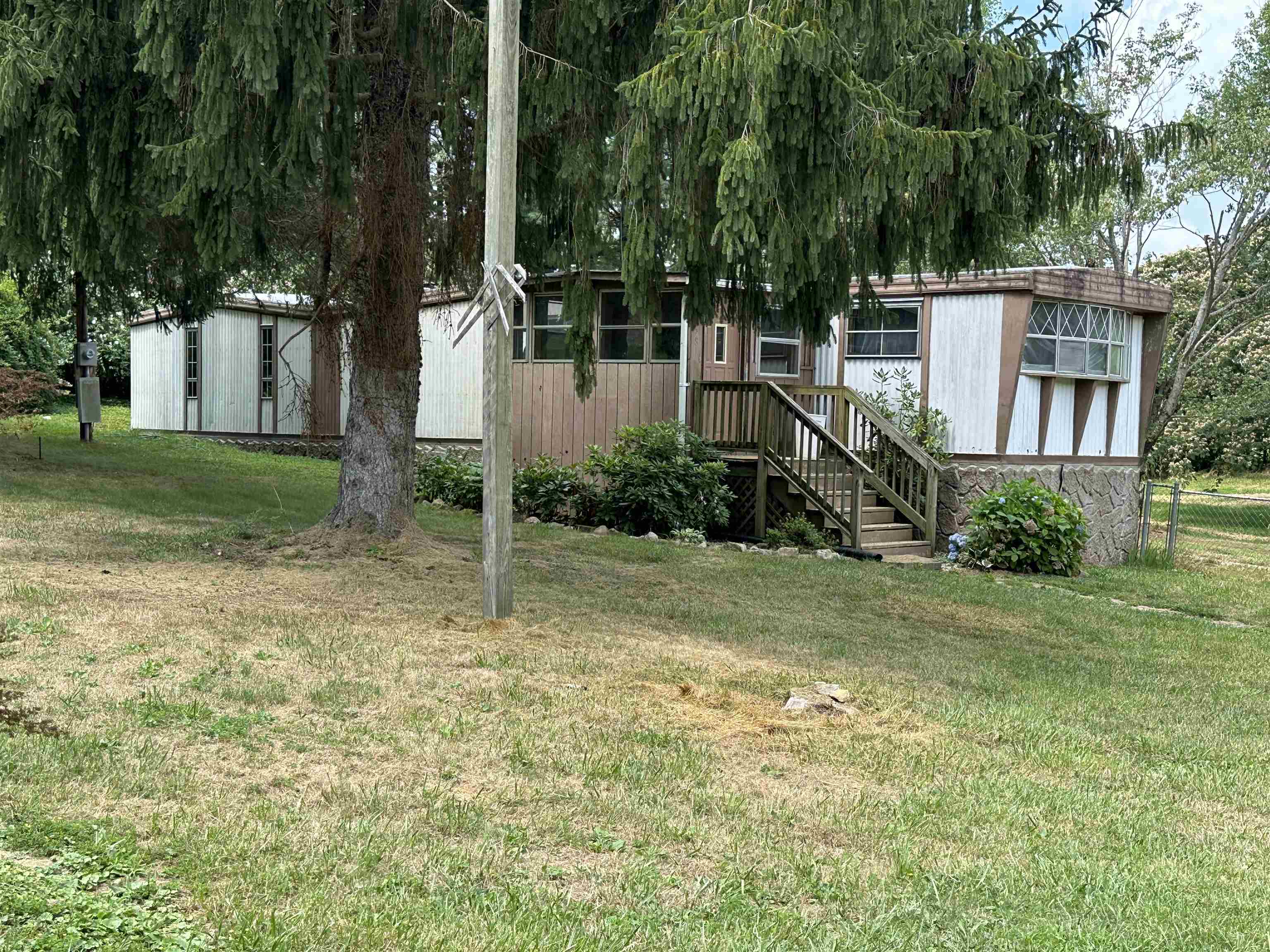 Mostly level lot with well, septic and electric on site. Single wide mobile home is on the property and included in "as is" condition. Trailer title has been obtained from DMV