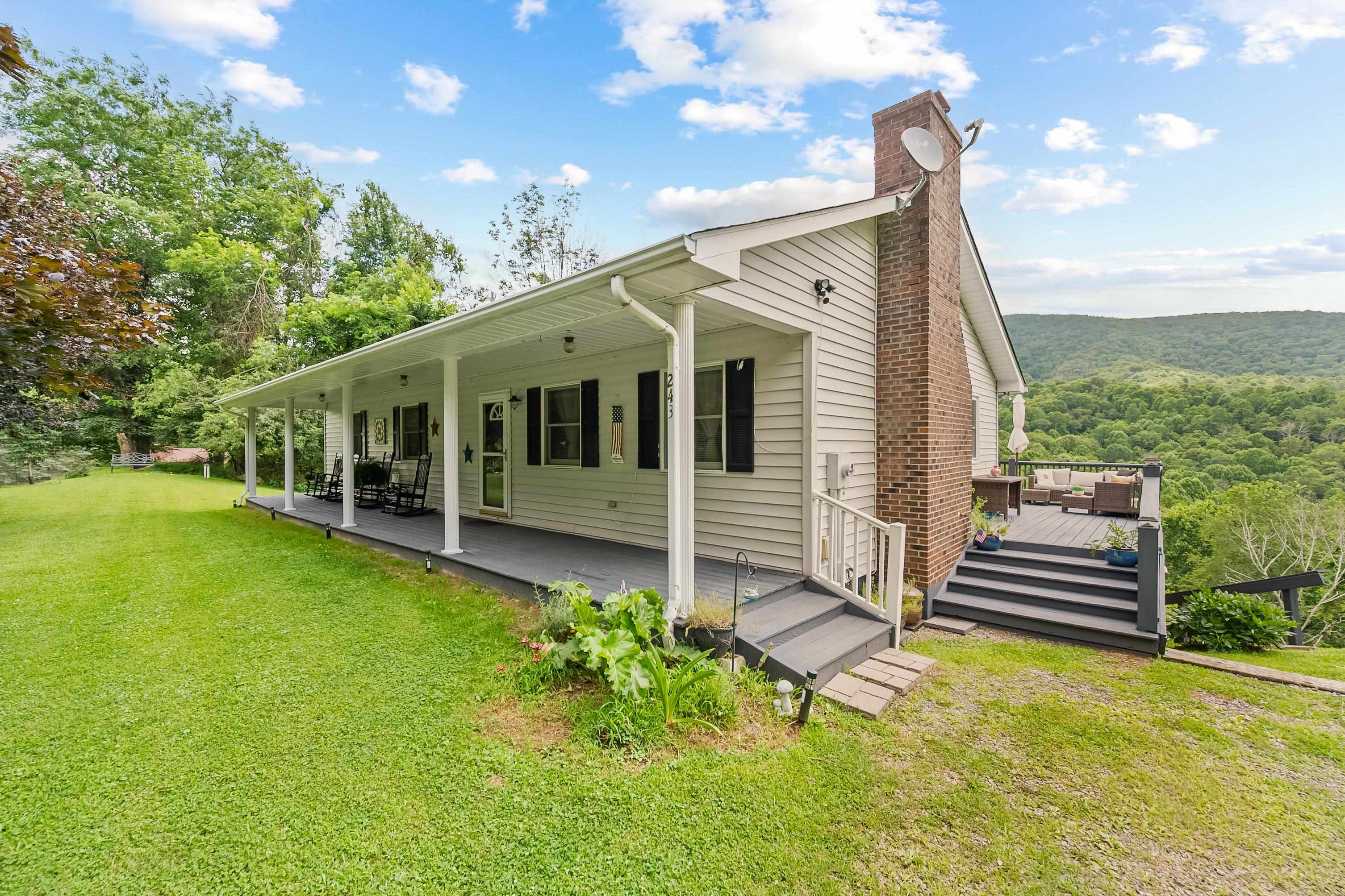 Escape to the Blue Ridge Mountains in this beautifully maintained 4BR/3BA home on 5 private acres just outside Independence, VA. Enjoy an open floor plan with gas-log fireplace, new tile and engineered laminate floors, fresh paint, and updated countertops. The dining area opens to an elevated back deck with mountain views—perfect for relaxing or entertaining. The main level features 3 bedrooms and 2 full baths, while the walkout basement includes a bonus room, third full bath, and a spacious den/flex space. Take in the peaceful setting from the covered front porch or open rear deck. You'll also enjoy access to a 9+ acre community lake, ideal for fishing or kayaking. Located near Grayson Highlands State Park, the New River, and local festivals, Independence offers charm, small-town hospitality, and endless outdoor recreation. Less than 2 hours from Roanoke, Charlotte, Boone, and Winston-Salem. A perfect mountain getaway or full-time residence!