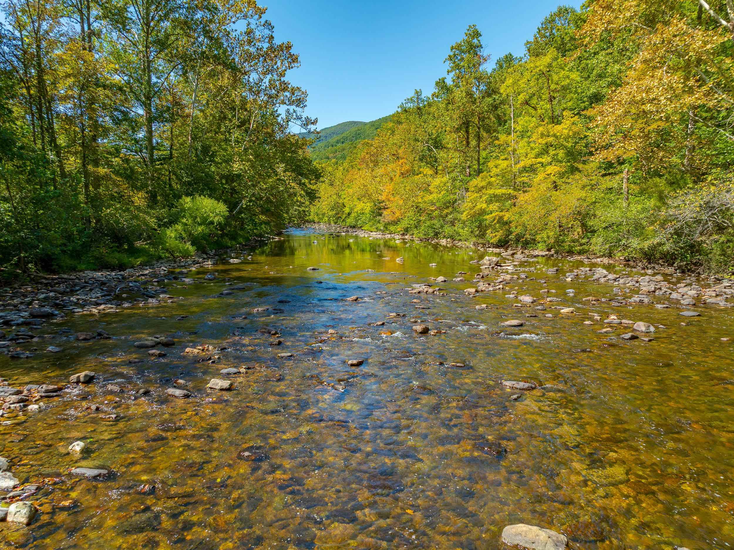 This remarkable 619-acre tract offers the perfect blend of a flat, cleared bottom and rugged mountain terrain, making it an ideal property for recreation, hunting, and investment. With over a mile of road and Wolf Creek frontage—including a super sturdy bridge crossing—you’ll enjoy easy access and the natural beauty of flowing water with fish. The property has been selectively timbered over the past 7 years (nothing below 14 inches harvested), leaving a healthy mix of mature hardwoods and young growth. Multiple roads and trails wind through the land all the way to the mountaintop, with cleared sites on different elevations perfect for food plots, campsites, or future cabin sites. Natural springs flow from multiple locations supplying reliable water for wildlife or potential off-grid living. A true hunter’s paradise, this property has been rested from hunting for the last 3–4 years, providing a safe haven for big game and enhancing its trophy potential. If these 619 acres isn't enough,