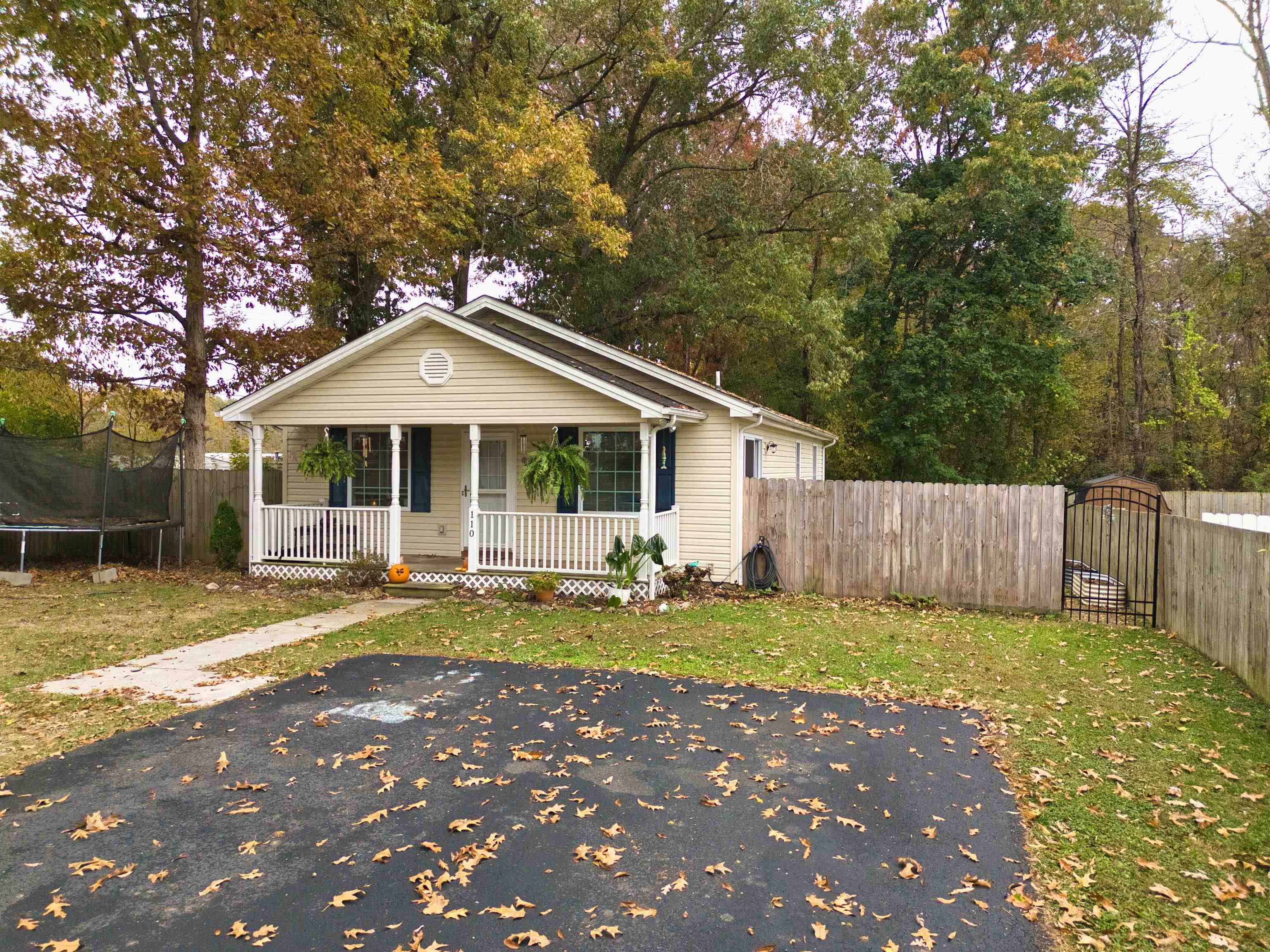 Welcome to this lovely home, offering comfort, privacy & efficiency—all on one convenient level! The spacious eat-in kitchen provides plenty of cabinet & counter space, perfect for cooking & entertaining. The open floor plan connects the kitchen & dining area w/ the living room creating a warm & inviting space for gatherings. Step outside onto the side deck to enjoy relaxing evenings or morning coffee. The primary bedroom features its own private bath, while two additional bedrooms share a well-appointed hall bathroom. The laundry area is conveniently located in a hall closet for easy access. You’ll appreciate the energy efficiency of 2x6 exterior walls with the addition insulation. Paved driveway offers ample parking & the privacy fence on three sides makes the backyard a peaceful retreat. A covered front porch provides the perfect spot for a couple of rocking chairs or porch swing! The storage building has lots of space too. Located at end of a cul-de-sac offers additional privacy!
