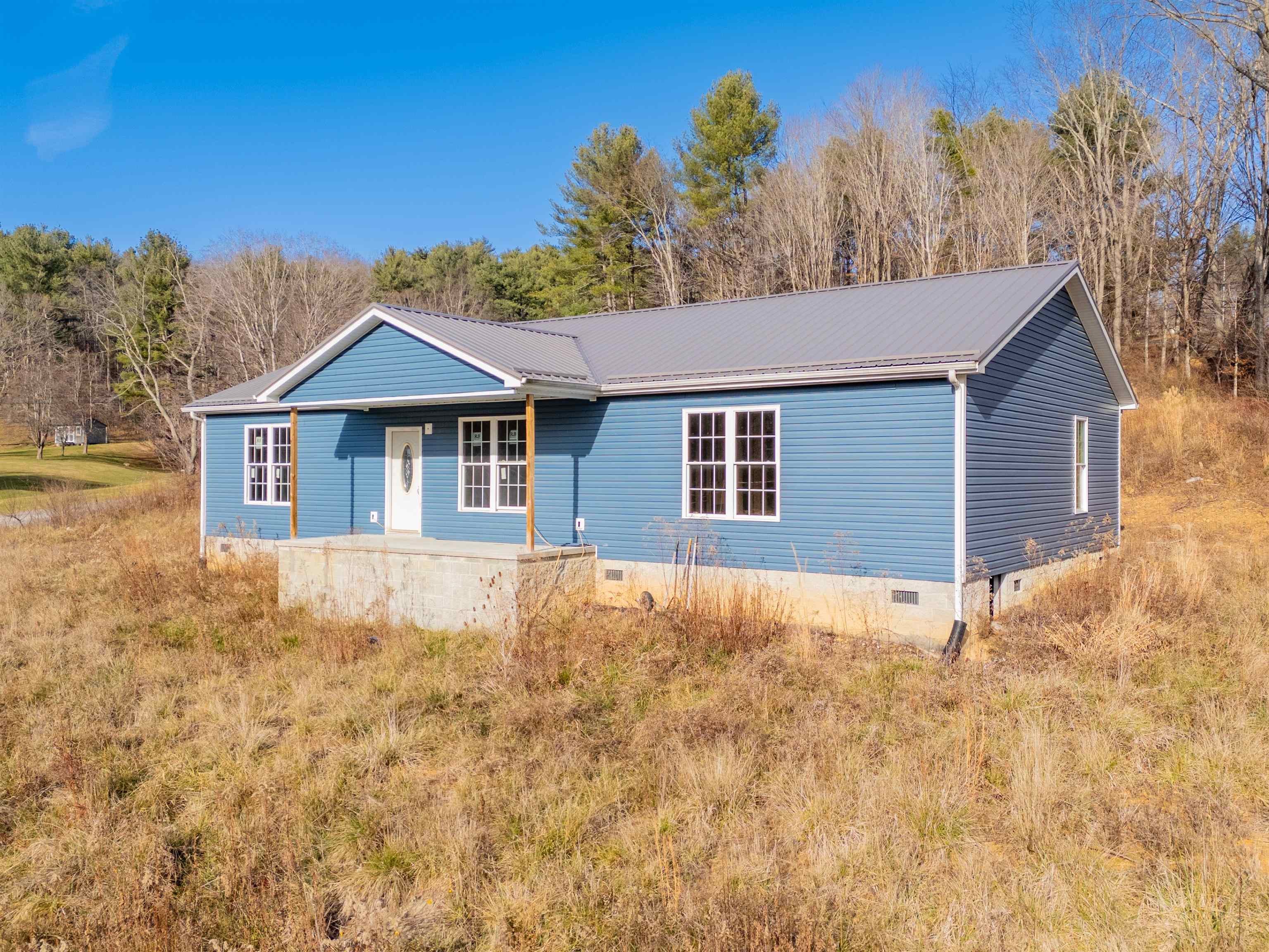 Discover the perfect blank canvas in this newly built ranch-style home offering approximately 1,920 sq ft of unfinished interior space—ready for you to design and complete exactly as you envision. The exterior is fully finished with low-maintenance vinyl siding, a durable metal roof, and inviting covered porches on both the front and rear of the home. Situated on a desirable corner location fronting US 52N and High Chaparral Lane in Bland, VA, this property offers both convenience and charm. Public water and sewer available with the county public water hookup fee already paid for the new owner. Enjoy being just minutes from the post office, courthouse, local grocery store, elementary school, and I-77, providing easy access between Bluefield, WV and Wytheville, VA. Whether you're seeking a custom home project or an investment opportunity, this property provides outstanding potential in a prime setting!